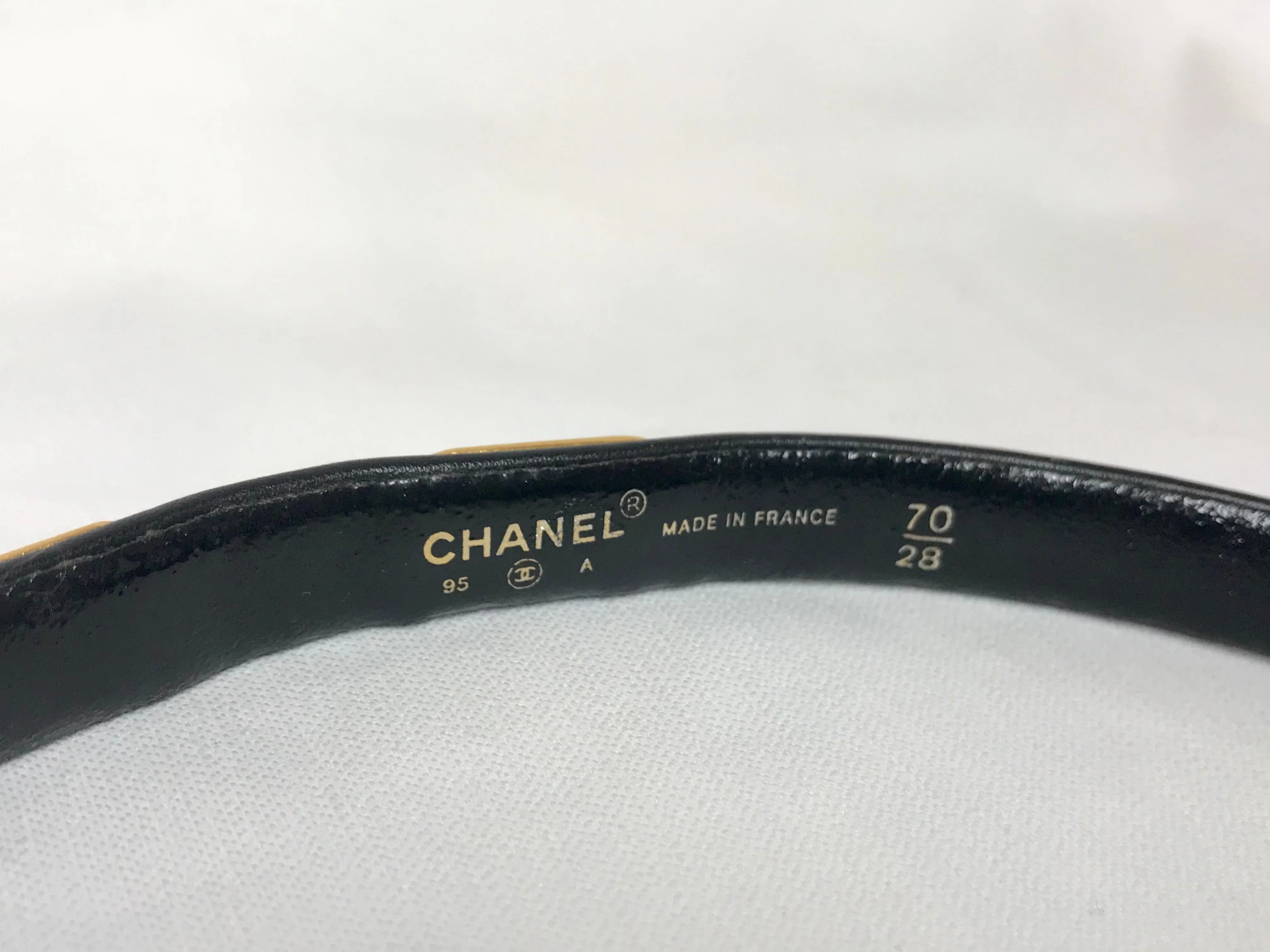 Vintage CHANEL black belt with golden buckle and iconic logo motifs, CC mark, camellia flower, turtle, perfume, clover. R0410113