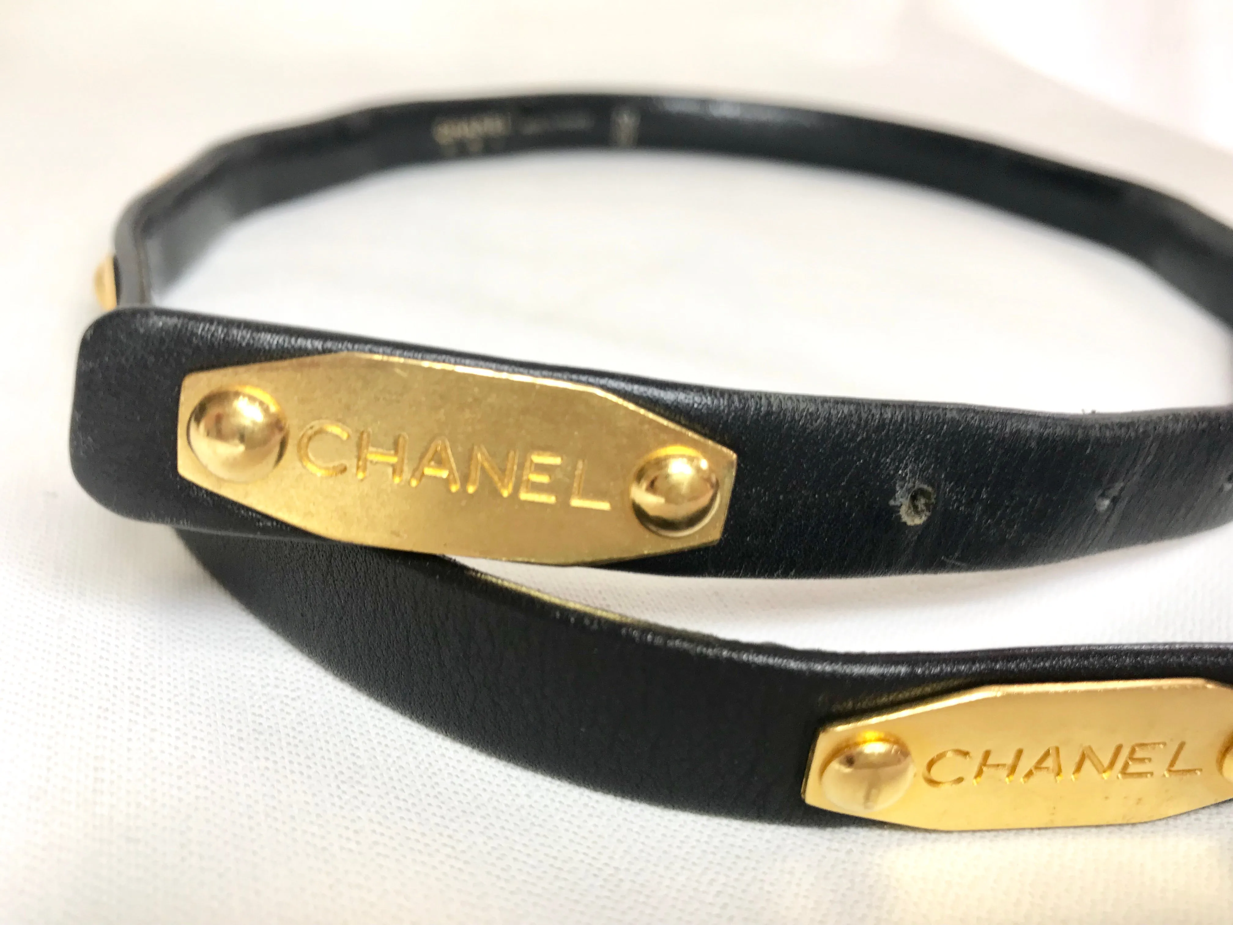 Vintage CHANEL black belt with golden buckle and iconic logo motifs, CC mark, camellia flower, turtle, perfume, clover. R0410113