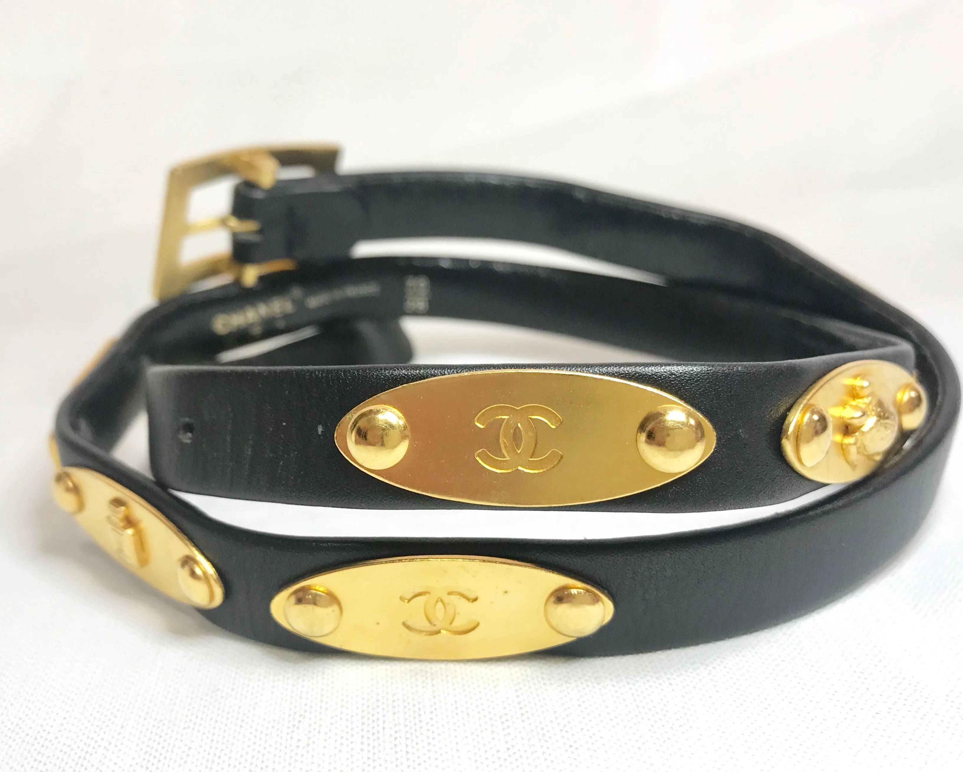 Vintage CHANEL black belt with golden buckle and iconic logo motifs, CC mark, camellia flower, turtle, perfume, clover. R0410113